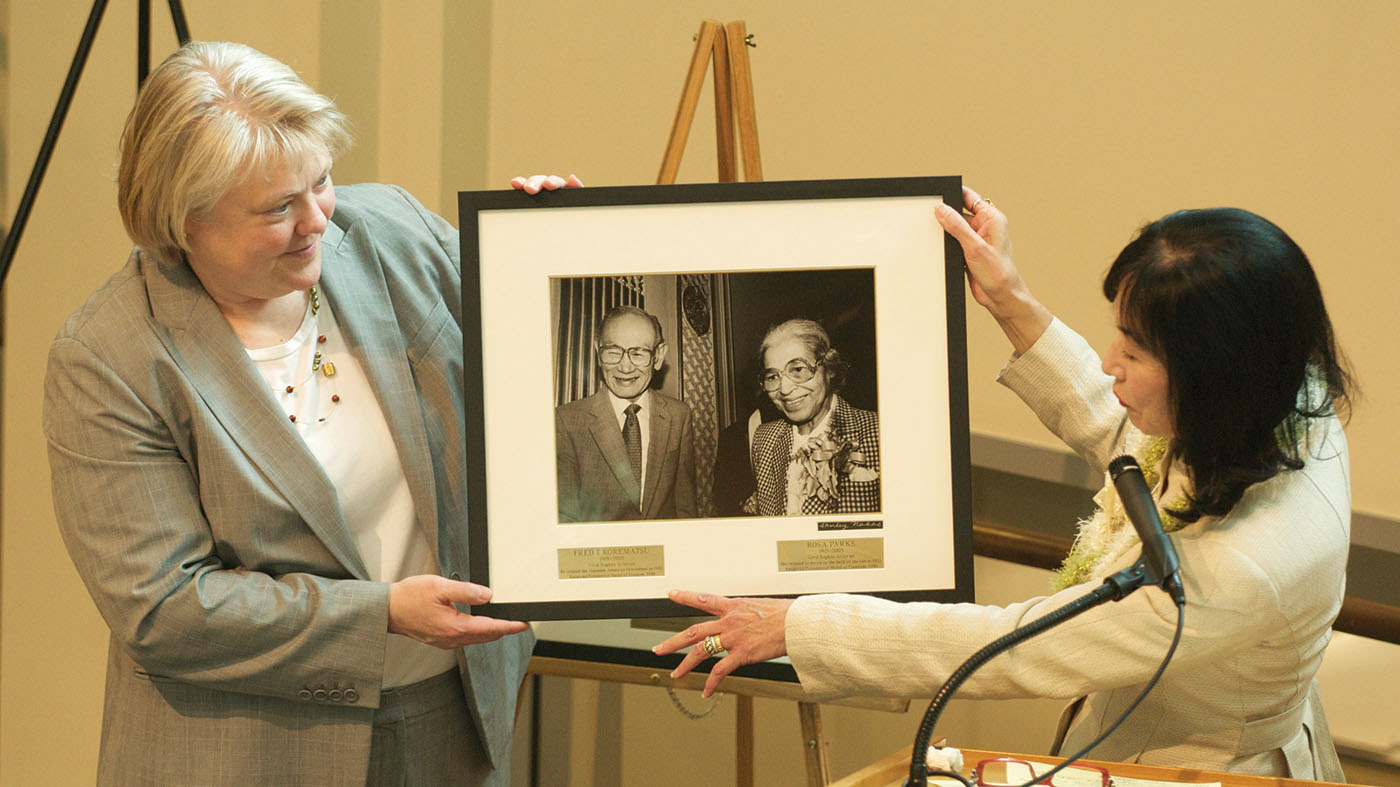 Karen Korematsu, right, presents a photo of her father, Fred, with Rosa Parks to Dean Kellye Testy and the law school during the dedication ceremony of the Fred T. Korematsu Center for Law and Equality.