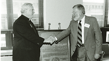 Seattle U President William J. Sullivan, S.J. (left), and Dean Don Carmichael shake hands during a ceremony in August of 1994 to officially mark the transfer of the law school to Seattle University.