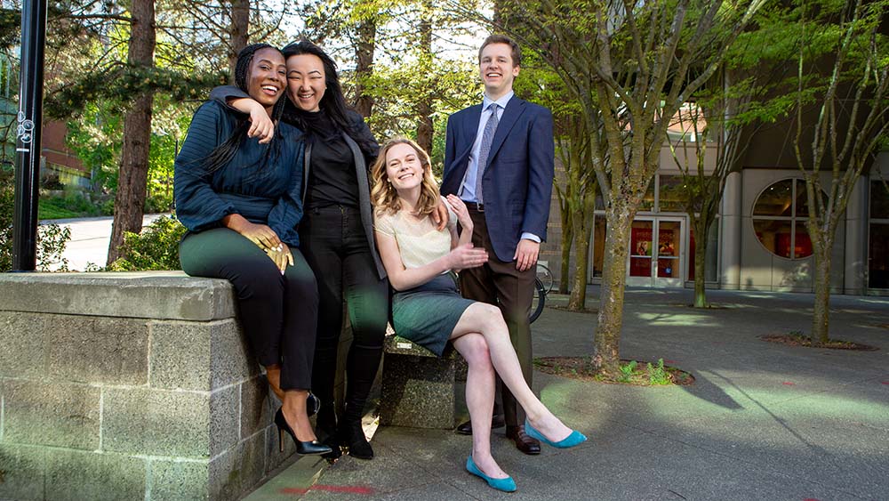 Four Seattle U Law students smiling outside of Sullivan Hall.