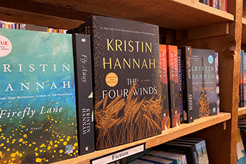 A bookshelf in a bookstore containing Kristin Hannah books