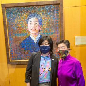First-year student Erin Lewis and Justice Mary Yu stand in front of the painted portrait of Justice Yu.