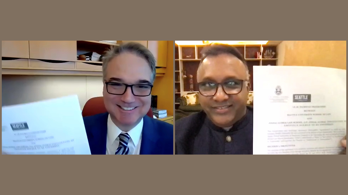 Dean Anthony E. Varona of Seattle University School of Law and Vice-Chancellor Prof. C. Raj Kumar of O.P. Jindal Global University (JGU) holds up signed partnership agreements during a virtual signing ceremony.