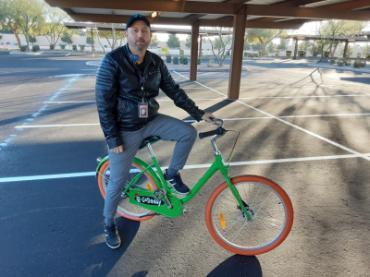 Alejandro Villegas sitting on a GoDaddy branded bike